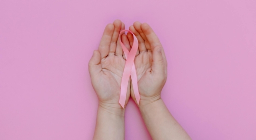 a person holding a pink ribbon